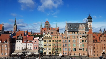 Zdjęcie Gdańska. Na zdjęciu widać maszt Czarnej Perły (statku rejsowego) a w oddali widnieje Bazylika Mariacka. Autor © Łukasz Suska