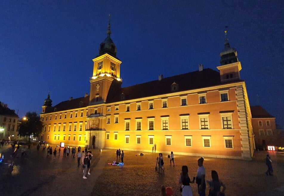 Zamek Królewski w Warszawie oświetlony sztucznym światłem lamp wieczorową porą.