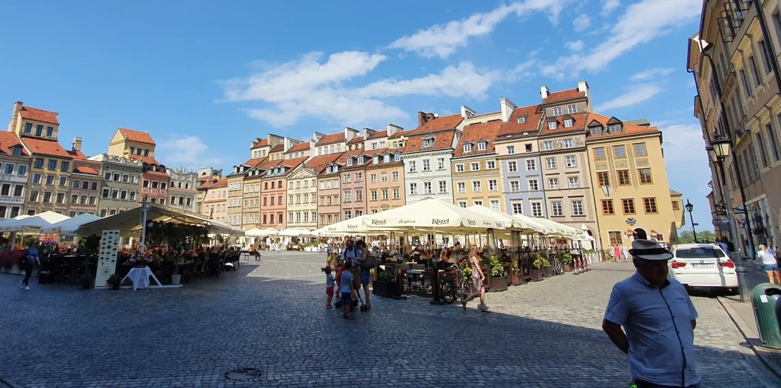 Warszawa - turyści spacerują w ciepły dzień po rynku starego miasta
