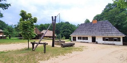 Skansen w Sierpcu - Karczma z Sochocina z wiejską studnią na środku podwórka